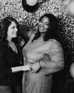 Greyscale photo of two women having fun in photo booth for wedding